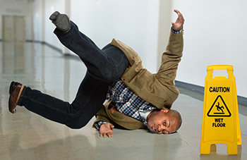 example office hazards - man tripping on wet floor